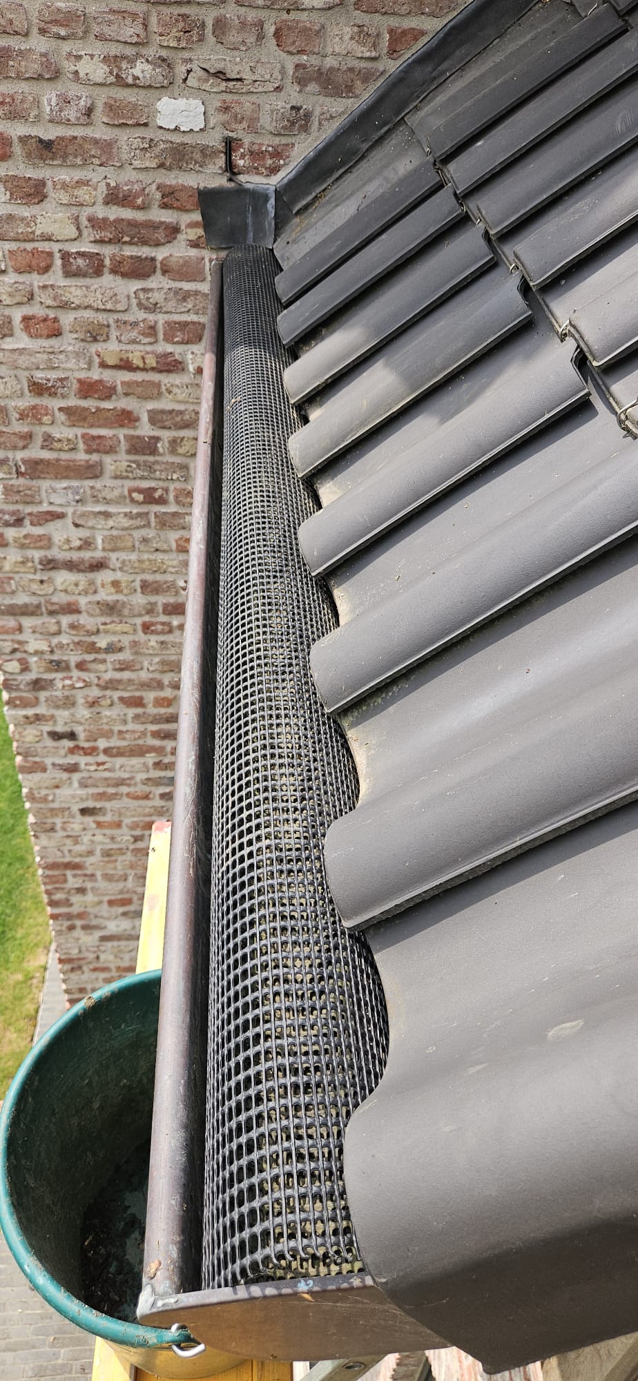 Dakgoot na reiniging Roeselare, beschermraster geplaatst